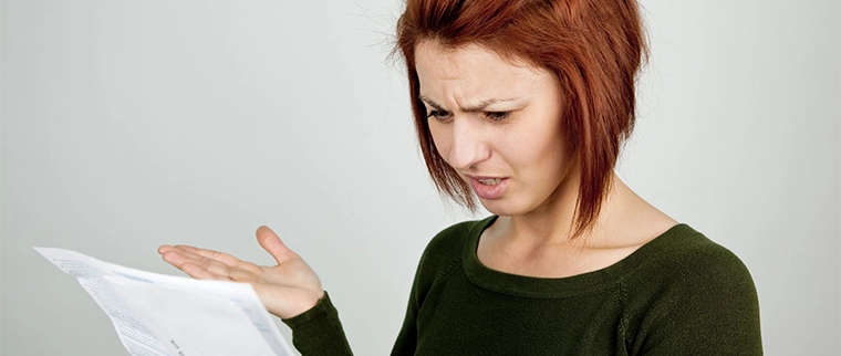 Frustrated woman looking at paper work